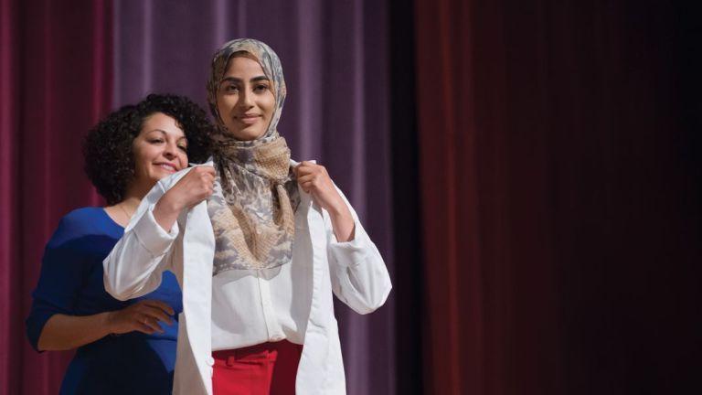 PharmD incoming student being cloaked at the White Coat Ceremony