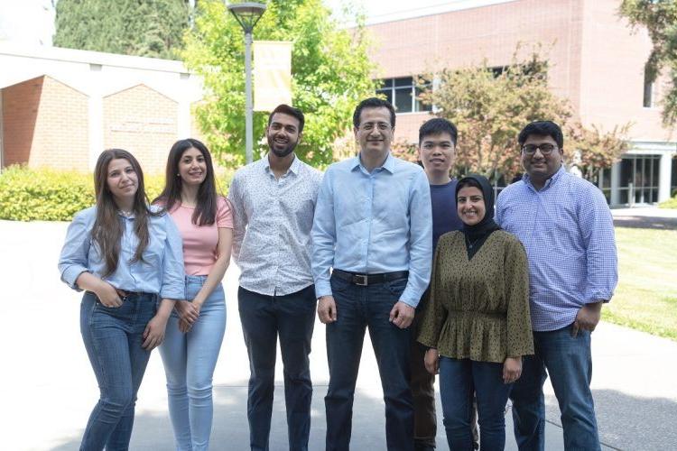 six students and a professor pose for a photo